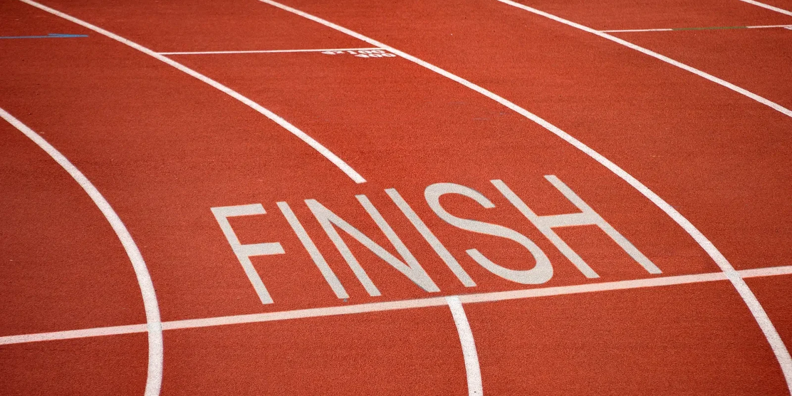 final-mile-delivery-finish-line-red Close-up of a red racetrack with several lanes and the word "finish" marked in white.
