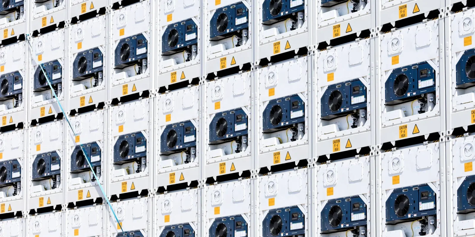 intermodal-refrigerated-containers-awaiting-drayage Many intermodal containers stacked at a port, awaiting drayage services. Only the temperature-control units of the containers are visible.