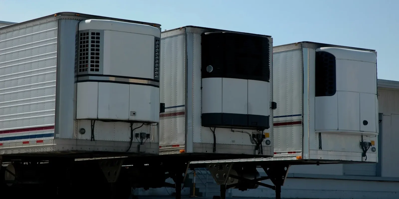 refrigerated-semi-trailers-loading-ltl-load Refrigerated semi trailers at a loading dock, receiving less-than-truckload (LTL) shipments.