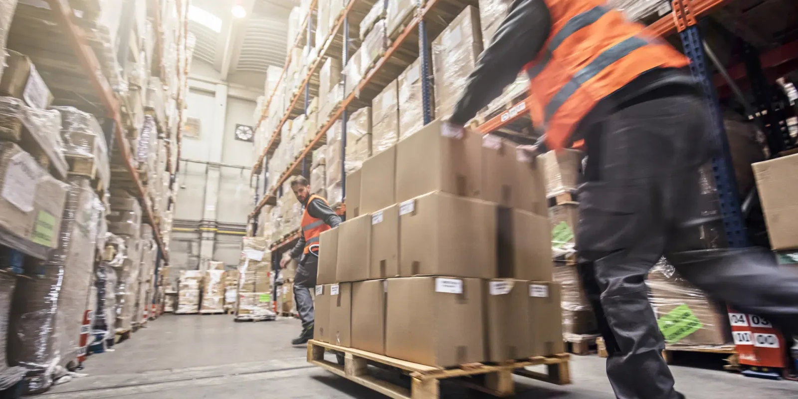 Trappers Transport workers move a pallet of freight quickly through a warehouse.