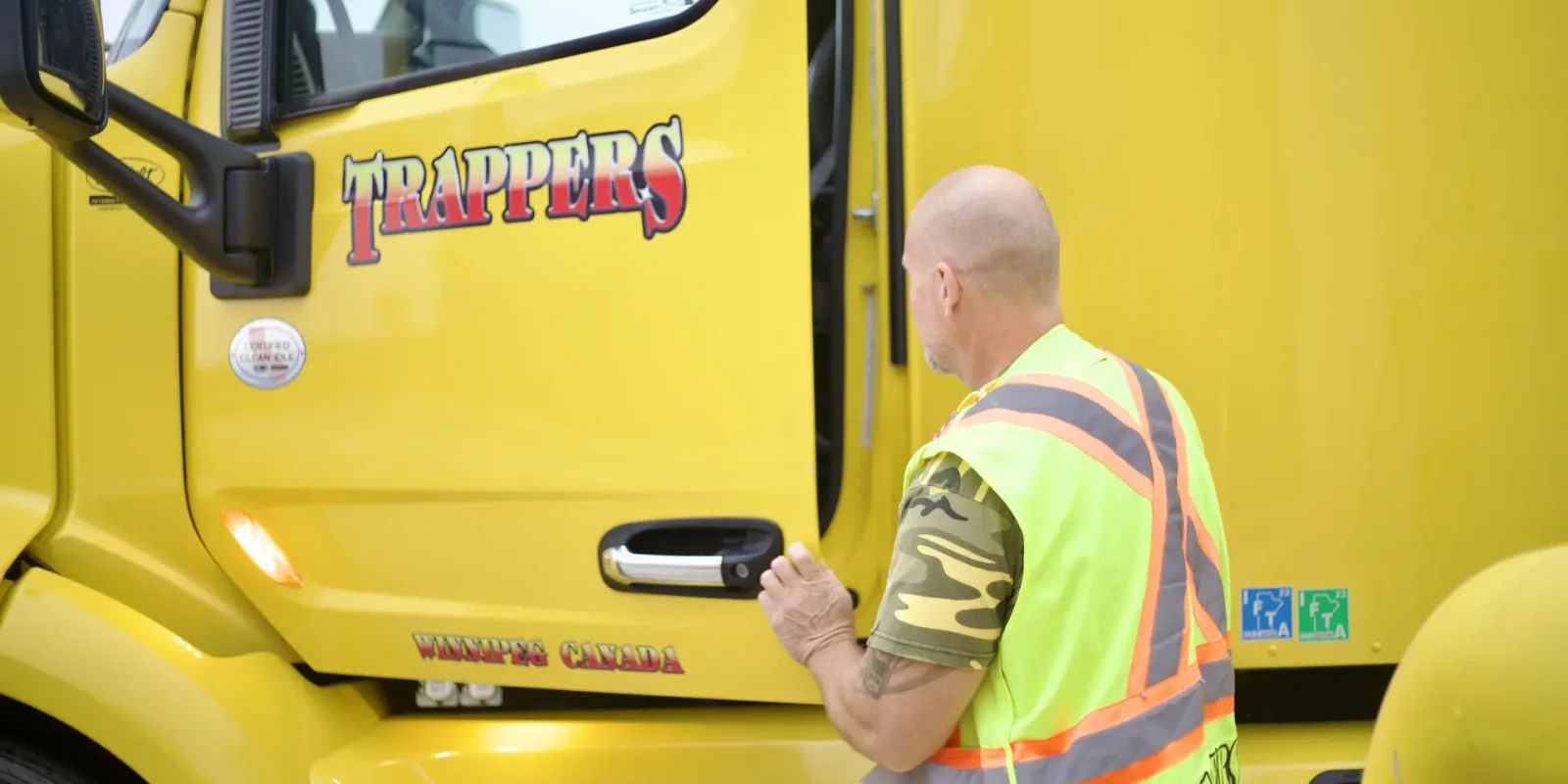 A Trappers Transport less than truckload driver inspecting the cab of a truck at the Hylife Manitoba facility.