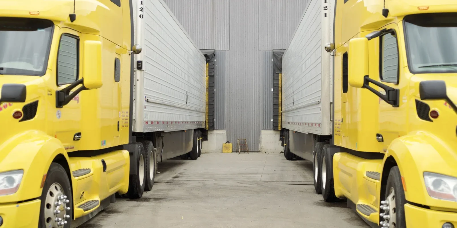 trappers-trucks-container-transload-facility-manitoba A pair of Trappers Transport trucks docked at their Winnipeg, Manitoba facility for container transloading.