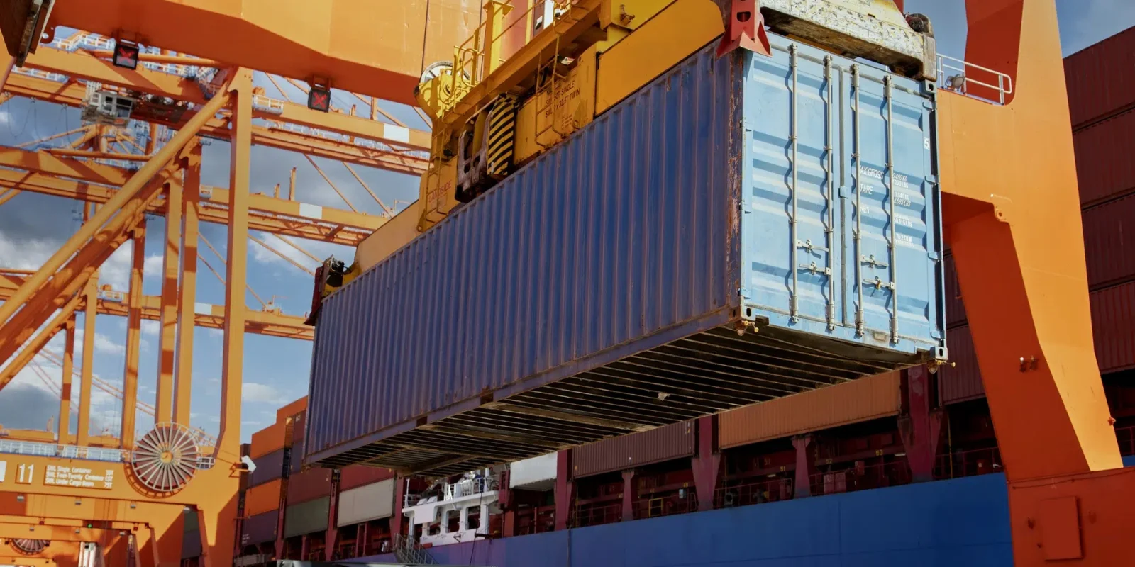 A temperature controlled transport container being carried by a crane at the Trappers Transport port in Vancouver.